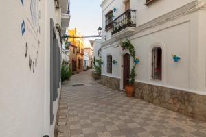 an alley in a town with white buildings at Factory Rooms Barbate in Barbate