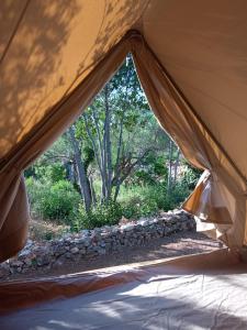 a tent with a view of a garden from inside at Mini kamp Perla in Prvić Luka