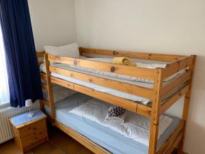 a wooden bunk bed with white pillows in a room at Frisiastraße 21 in Norderney