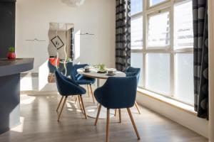 uma sala de jantar com uma mesa e cadeiras azuis em Albert Goupil - LAVALOC em Laval