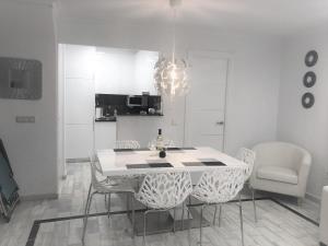 Un comedor blanco con una mesa y sillas. en Beach Dream Apartment, en La Mata