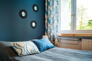 a blue bedroom with a bed and a window at Czas na Puszczę in Puszcza Mariańska