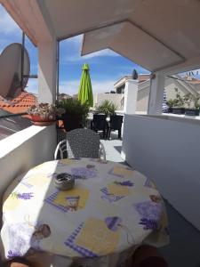 a table and a chair on a balcony with a view at Apartments Knežić in Igrane
