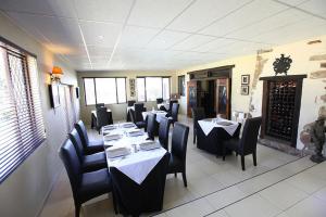 a dining room with tables and chairs in a restaurant at Lauriston Guesthouse in Centurion