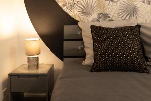łóżko z lampką i poduszką w obiekcie Albert Goupil - LAVALOC w mieście Laval