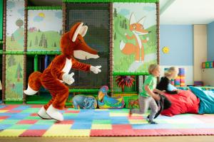 a young boy and a child playing in a room with a stuffed animal at OREA Resort Sklář Harrachov in Harrachov
