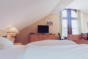 a bedroom with a large bed and a tv at Gästehaus Samuel Wadgassen in Wadgassen