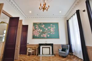 una sala de estar con chimenea y una pintura en la pared en Meublés de l'Arsenal cœur de ville !, en Angulema