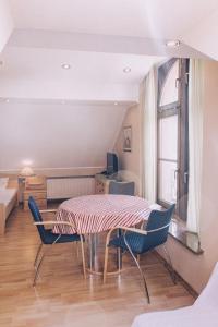 a room with a table and chairs and a bed at Gästehaus Samuel Wadgassen in Wadgassen