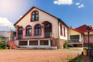 a large house with red windows and a porch at Gästehaus Samuel Wadgassen in Wadgassen