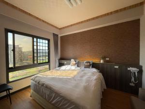 Ein Mann, der in einem Zimmer mit Fenster in einem Bett liegt in der Unterkunft Otter Hotel in Jinhu
