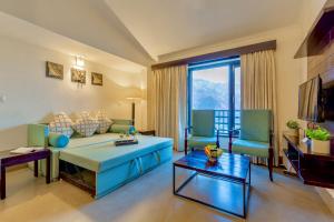 uma sala de estar com um sofá azul e cadeiras em Rosewood Retreat Bhimtal em Bhimtal