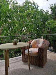 einen Korbstuhl und einen Tisch auf dem Balkon in der Unterkunft Tropical Nights 3 in Cala Millor
