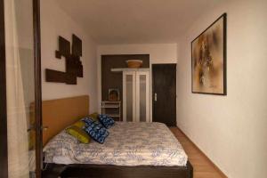 a bedroom with a bed with blue pillows on it at Tropical Nights 2 Apartamento cerca de la playa in Cala Millor