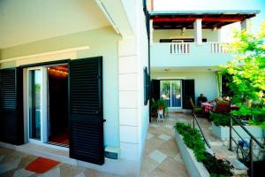 a house with a black door and a patio at Villa with pool Split - Supetar Island Brac in Supetar