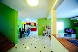 a living room with green walls and a dining room at Villa with pool Split - Supetar Island Brac in Supetar