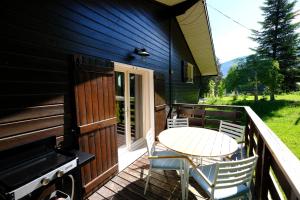 a deck with a table and chairs on a house at Chalet des Bruyeres in Lans-en-Vercors