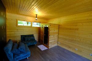 a room with two couches in a wooden cabin at Chalet des Bruyeres in Lans-en-Vercors