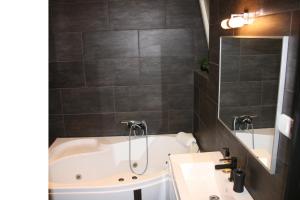 a bathroom with a bath tub and a sink at Smart Apartments in Budapest