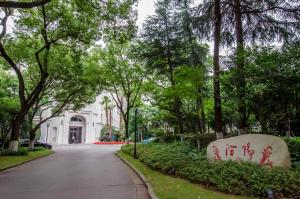 a street in front of a white building with trees at Shanghai Fenyang Garden Boutique Hotel in Shanghai