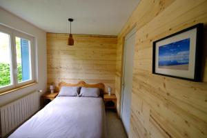 sypialnia z łóżkiem w drewnianej ścianie w obiekcie Gite des Rosiers w mieście Lans-en-Vercors