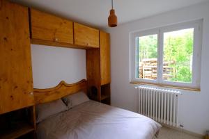 a bedroom with a bed and a window at Gite des Rosiers in Lans-en-Vercors