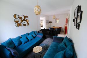 uma sala de estar com um sofá azul e uma mesa em Gite des Rosiers em Lans-en-Vercors