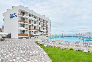 a hotel with a swimming pool in front of a building at Lucky Residence in Zatoka