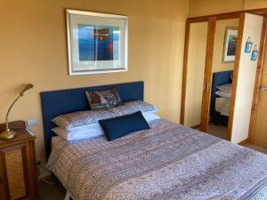 a bedroom with a bed with a blue head board at The Boat Shed in Sandford