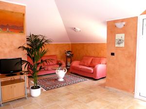 a living room with a couch and a tv at L'Albicocco in Dolceacqua