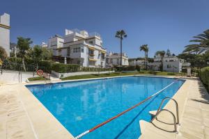 una gran piscina frente a un edificio en Casa Del Sol, en Marbella