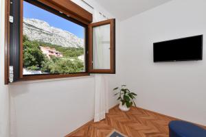 a room with a window with a view of a mountain at Apartments Marsela in Tučepi