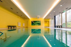 a swimming pool with blue tile floors and yellow walls at Schlosspark Hotel in Berlin