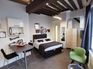 a bedroom with a bed and a table and chairs at Le Saint-Aignan, Nuits-chartraines, Parking privé a quelques minutes, 3 étoiles in Chartres