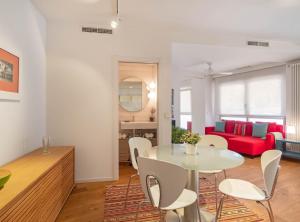 a living room with a table and chairs and a red couch at Paseo de la Habana II in Madrid