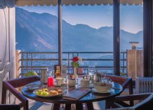 a table with food on it with a view of mountains at Rosewood Retreat Bhimtal in Bhīm Tāl