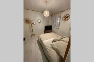 een kleine slaapkamer met een bed en een televisie bij Le Cocoon - 2mn gare SNCF, hyper centre, WIFI-NETFLIX in Niort