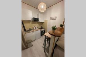 een kleine keuken met witte kasten en een tafel bij Le Cocoon - 2mn gare SNCF, hyper centre, WIFI-NETFLIX in Niort