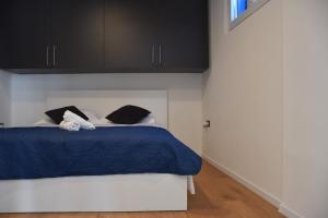 a bedroom with a blue bed with black cabinets at Apartman Lucana in Tribunj +53 photos