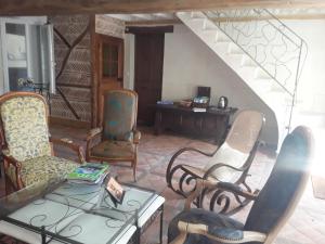 a living room with chairs and a table and a staircase at Atypiques Confitures, Chambres d'Hôtes in Couffy