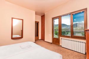 a bedroom with a bed and a large window at Tsaghkadzor Homeland in Tsaghkadzor