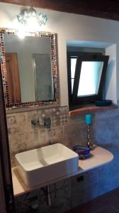 ein Badezimmer mit einem weißen Waschbecken und einem Spiegel in der Unterkunft Casina di Vicchio in Dicomano
