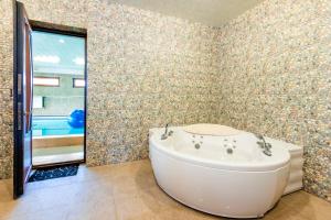 a bathroom with a tub in a room with a window at Tsaghkadzor Homeland in Tsaghkadzor +23 photos