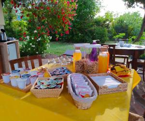 ein gelber Tisch mit Speisen und Getränken darauf in der Unterkunft Il Girasole Country House in Camerano