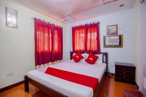 sypialnia z dużym łóżkiem z czerwonymi zasłonami w obiekcie OYO 741 Sierra Travellers Inn w mieście Tagaytay