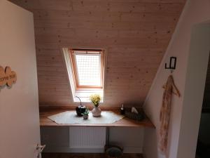 ein kleines Zimmer mit einem Fenster in einer Holzwand in der Unterkunft B&B Lekker Buiten in Stratendries