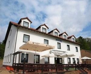 a large white building with an umbrella in front of it at Hotel Am Schiffshebewerk in Niederfinow