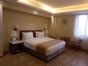 a bedroom with a bed and two tables and a window at Lego Star Hotel in Addis Ababa +21 photos
