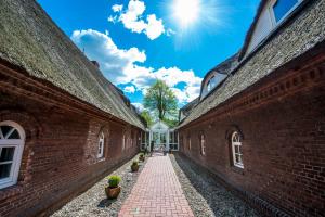 an alley between two brick buildings with the sun in the sky at Hotel Gut Schöneworth in Freiburg - Elbe