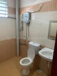 a bathroom with a toilet and a sink at RJ Homey Guesthouse in Sungai Petani